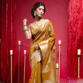 Women Banarasi Kora Cotton Saree In Mustard Yellow Color With Zari Motifs And Chakra Border